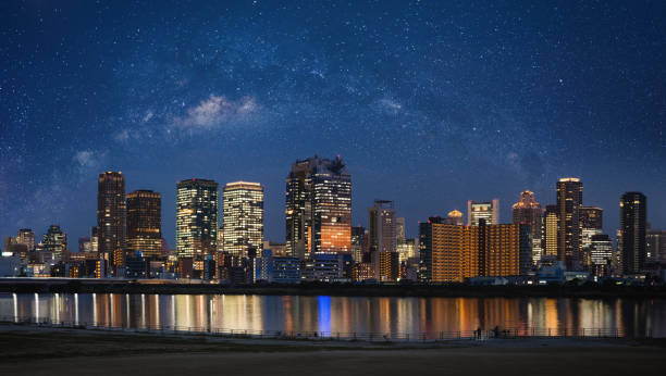 星空を眺めながら、関西の大阪市を夜景に。パノラマ都市の背景 - 近畿地方 ストックフォトと画像