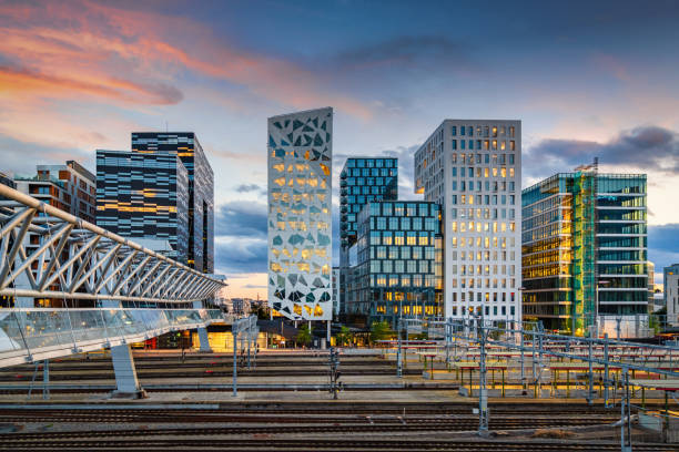 Oslo Business Skyline at Sunset Twilight, Norway Sunset twilight over downtown Oslo, the capital city of Norway. Pedestrian Bridge over rails of central railway station on the left. Illuminated modern Business Buildings and Skyscaper Cityscape in late Summer at Dusk. Oslo, Norway, Scandinavia oslo stock pictures, royalty-free photos & images