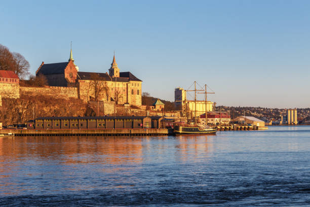 Oslo city skyline and harbor in front of Akershus Fortress during sunset in Norway stock photo