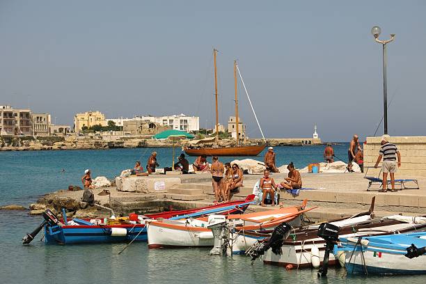Otranto Italy sunbathers on pier stock photo