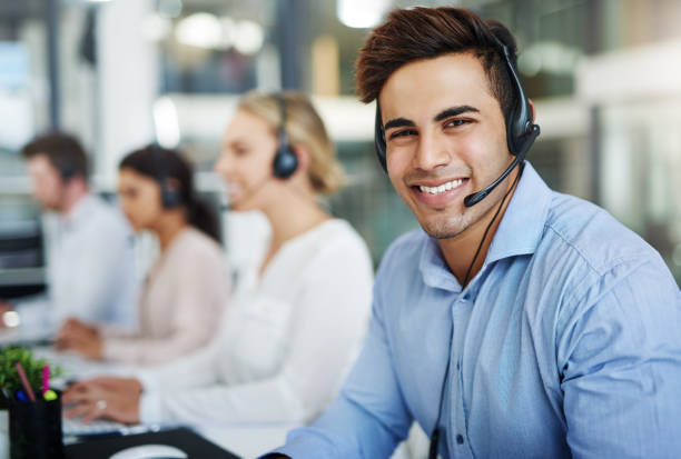 Our contact centre consultants are 100% customer focused Portrait of a handsome young man working next to his team in a call center call center photos stock pictures, royalty-free photos & images