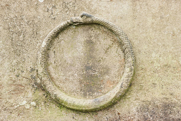 Ouroboros Carving "An Ouroboros - a snake eating its own tail - carved on a Victorian gravestone in Glasgow's Necropolis cemetery.It symbolises unity and infinity, as well as the cycle of birth, life, death and rebirth." theasis stock pictures, royalty-free photos & images