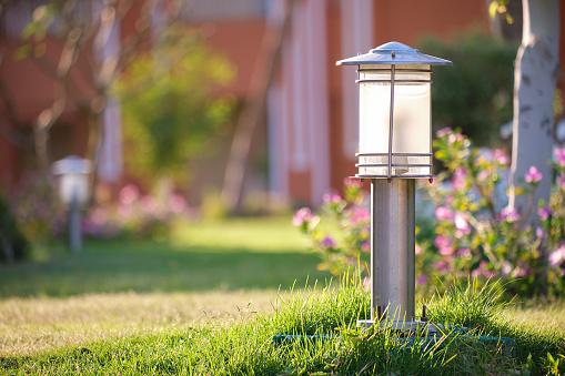 Outdoor lamp on yard lawn for garden lighting in summer park.
