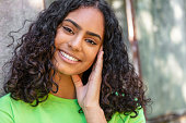 istock Outdoor portrait of beautiful happy mixed race African American girl teenager female young woman thinking and smiling with perfect teeth 1334306730