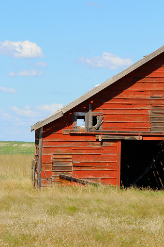 Outdoor rural scene of a portion of the entrance to an old weathered agricultural building.