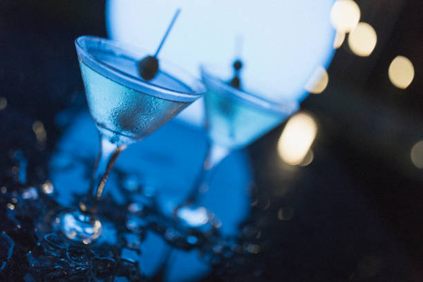 Outdoors night shot of two martinis with olives, as shot in Nassau. Cocktail photography. dirty martini stock pictures, royalty-free photos & images