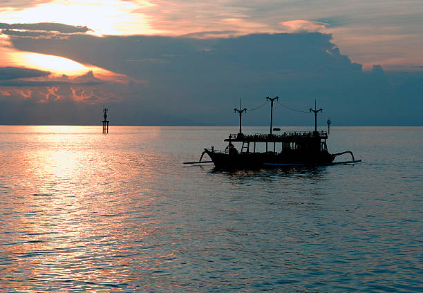 Outrigger boat at Sunset, Candi Dasa, Bali stock photo