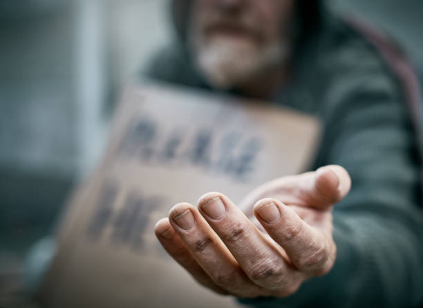 Outstretched hand of pathetic beggar A pathetic homeless man begs on the sidewalk. homelessness stock pictures, royalty-free photos & images