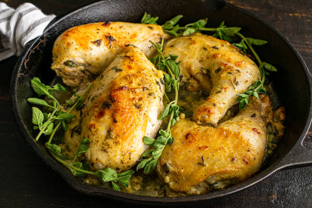 Oven-Roasted Greek Chicken Quarters in a Cast-Iron Skillet Pieces of chicken marinated in Greek yogurt, lemons, and herbs chicken thigh meat stock pictures, royalty-free photos & images