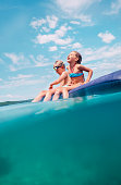 Over the deep blue sea: two childs have a fun when swim on inflatable mattress in the sea lagoon