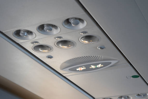Overhead lights, air conditioning and safety signs in the plane cabin stock photo