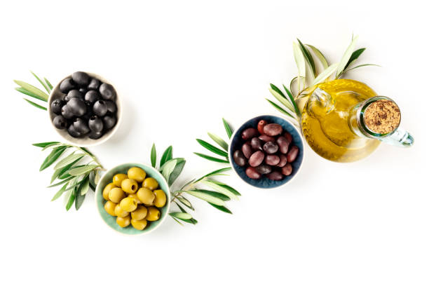 Overhead photo of various olives in bowls and a cruet of olive oil, shot from the top on a white background with copy space Overhead photo of various olives in bowls and a cruet of olive oil, shot from the top on a white background with copy space green olives jar stock pictures, royalty-free photos & images