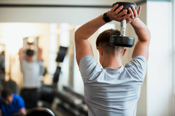 Overhead Triceps Dips with a Dumbbell stock photo