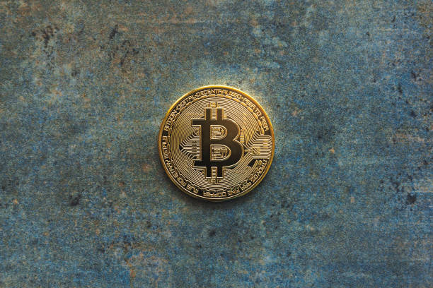 Overhead view of a isolated bitcoin on a textured background and copy space. Golden BTC coin, Stock Market of cryptocurrencies and decentralized finances concept stock photo