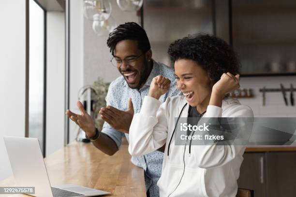 Overjoyed biracial couple celebrate lottery win on laptop