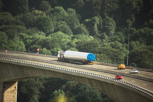 Oversize load trailer on highway viaduct An oversize load trailer, carrying a part of a wind turbine, on a highway viaduct oversized object stock pictures, royalty-free photos & images