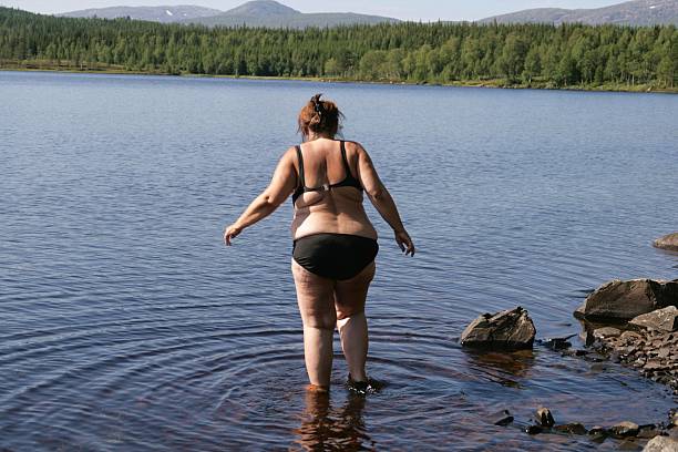 Overweight woman in bikini stock photo