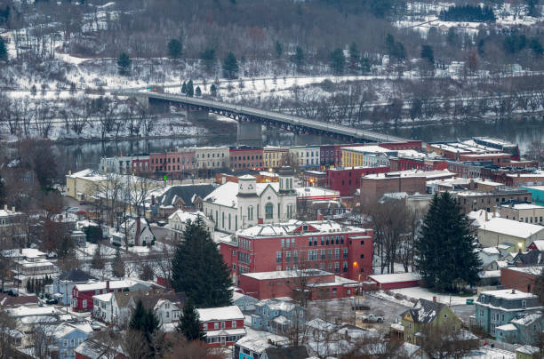 Owego is a small village in New York State, located along the Susquehanna River, photographed from the top of a hill during a winter morning with fresh snow on rooftops. stock photo