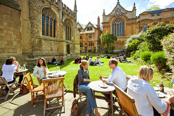 Oxford, UK "Oxford, England - May 8, 2011: People sitting outside the University Church of St. Mary the Virgin to enjoy a sunny spring day. The University of Oxford is one of the leading universities worldwide." oxford university stock pictures, royalty-free photos & images