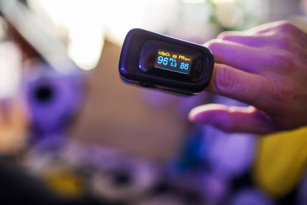 COVID-19 Oximeter For Checking Oxygen Saturation in Blood Oximeter for checking oxygen saturation in blood on male hand oxygen stock pictures, royalty-free photos & images