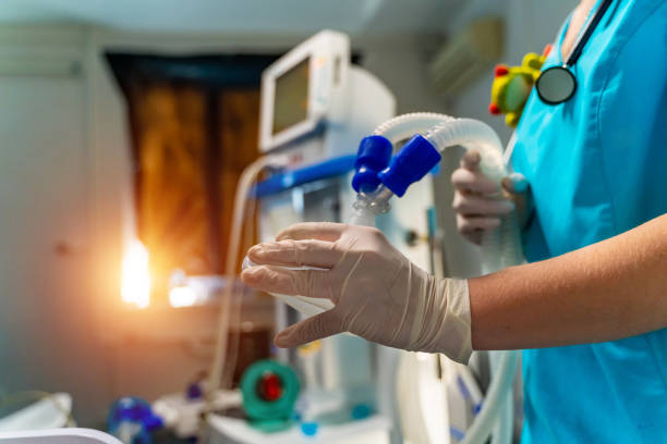 Oxygen mask. Anesthetist holding oxygen mask above patient. Intensive care unit stock photo