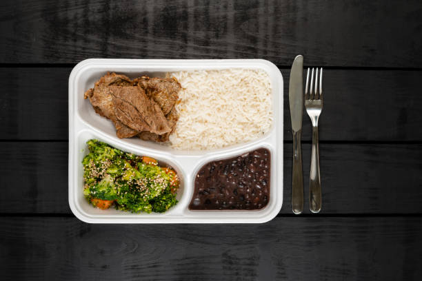 Packed lunch - beef, broccoli and carrot baked with sesame, white rice and black beans stock photo