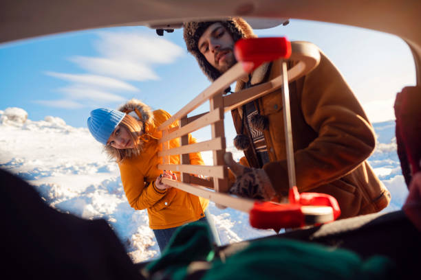 verpacken des schlittens ins auto - auto packen für den urlaub winter stock-fotos und bilder
