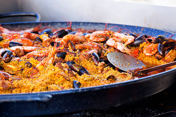 Paella at the Food Market "The classic Spanish food dish, a seafood Paella, containing mussels,shrimp and lobster, being sold at a Food Market," comunidad autonoma de valencia stock pictures, royalty-free photos & images