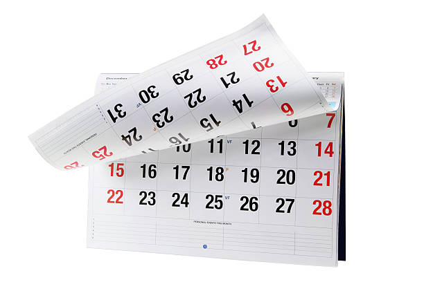 Page of calendar month curls upwards revealing the next page stock photo