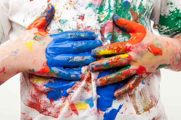 Paint soiled hands being wiped on a white shirt stock photo