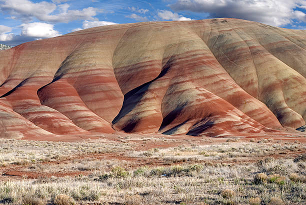 Painted Hills in Oregon Horizontal landscape of the colorful Painted Hills in Oregon aganist cloudy blue skies. fossil site stock pictures, royalty-free photos & images