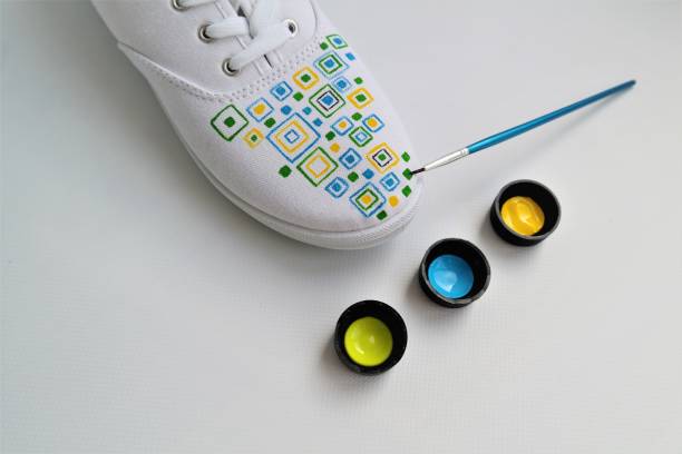 Painting white sneakers with your own hands stock photo
