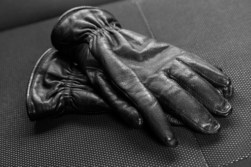 pair of black leather gloves, detail of texture and wrinkles, clothing accessory
