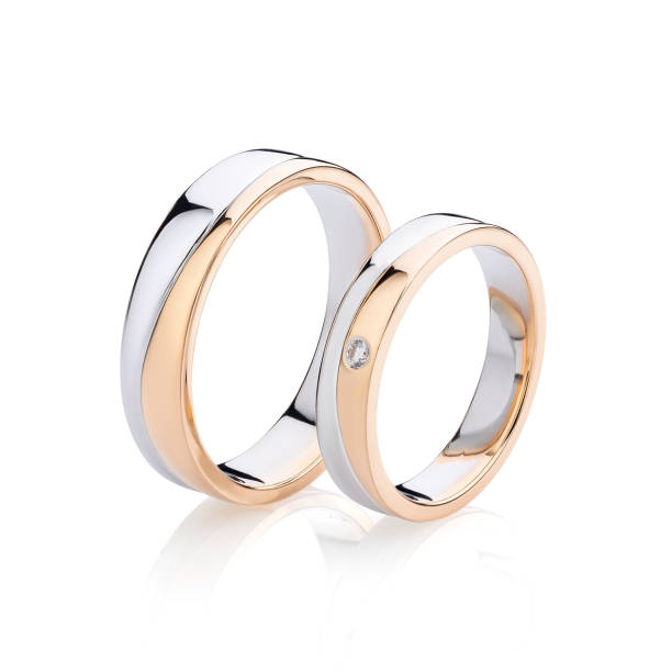 Pair of pink gold and silver wedding rings isolated on white background Pair of pink gold and silver wedding rings isolated on white background. Female ring decorated with diamond. Silver and gold wedding ring bands ring jewelry stock pictures, royalty-free photos & images