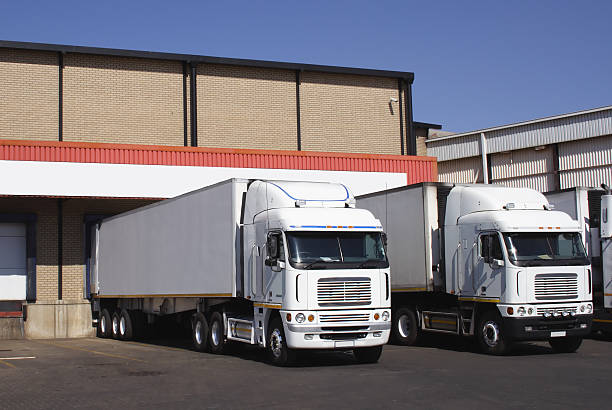 pair of refrigerated transporters at a food warehouse loading dock stock photo