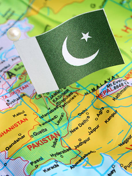 Pakistan Pakistani flag over cheap plastic map pointing Islamabad. Shallow depth of field pakistan flag stock pictures, royalty-free photos & images