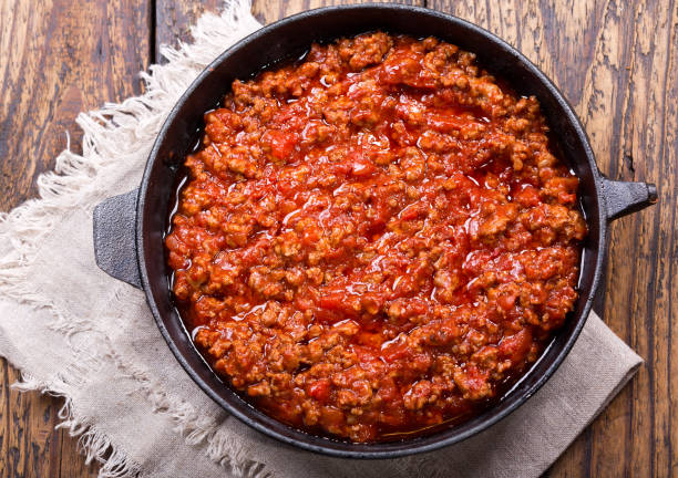 pan of sauce bolognese on wooden table stock photo