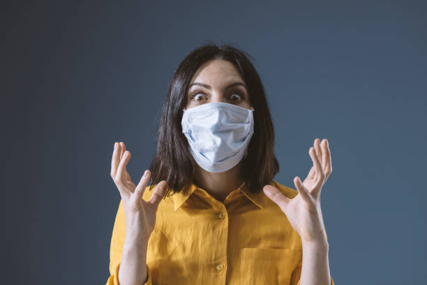 donna in preda al panico che indossa una maschera facciale contro covid-19 - stress foto e immagini stock