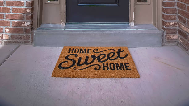 Panorama frame Wreath and doormat on the front door with sidelights and transom window stock photo