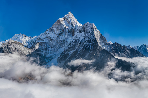 XXXXL size panorama of Mount Ama Dablam - probably the most beautiful peak in Himalayas. 
 This panoramic landscape is an very high resolution multi-frame composite and is suitable for large scale printing
Ama Dablam is a mountain in the Himalaya range of eastern Nepal. The main peak is 6,812  metres, the lower western peak is 5,563 metres. Ama Dablam means  'Mother's neclace'; the long ridges on each side like the arms of a mother (ama) protecting  her child, and the hanging glacier thought of as the dablam, the traditional double-pendant  containing pictures of the gods, worn by Sherpa women. For several days, Ama Dablam dominates  the eastern sky for anyone trekking to Mount Everest basecamp