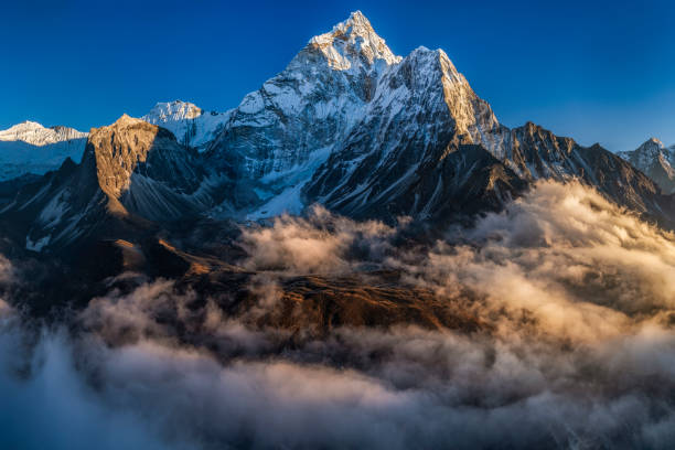 Panorama of beautiful  Mount Ama Dablam in  Himalayas, Nepal XXXXL size panorama of Mount Ama Dablam - probably the most beautiful peak in Himalayas. 
 This panoramic landscape is an very high resolution multi-frame composite and is suitable for large scale printing
Ama Dablam is a mountain in the Himalaya range of eastern Nepal. The main peak is 6,812  metres, the lower western peak is 5,563 metres. Ama Dablam means  'Mother's neclace'; the long ridges on each side like the arms of a mother (ama) protecting  her child, and the hanging glacier thought of as the dablam, the traditional double-pendant  containing pictures of the gods, worn by Sherpa women. For several days, Ama Dablam dominates  the eastern sky for anyone trekking to Mount Everest basecamp himalayas stock pictures, royalty-free photos & images