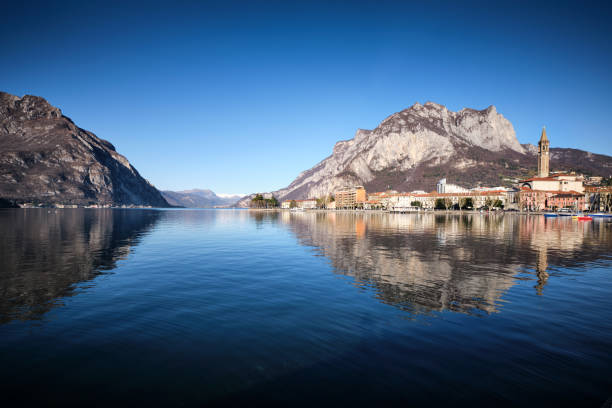 panorama di lecco riflesso sul lago - lombardia foto e immagini stock