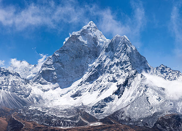 Panorama of Mount Ama Dablam in Nepal Ama Dablam is a mountain in the Himalaya range of eastern Nepal. The main peak is 6,812  metres (22,349 ft), the lower western peak is 5,563 metres (18,251 ft). Ama Dablam means  "Mother's neclace"; the long ridges on each side like the arms of a mother (ama) protecting  her child, and the hanging glacier thought of as the dablam, the traditional double-pendant  containing pictures of the gods, worn by Sherpa women. For several days, Ama Dablam dominates  the eastern sky for anyone trekking to Mount Everest basecamp.http://bhphoto.pl/IS/nepal_380.jpg himalayas stock pictures, royalty-free photos & images