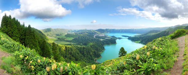 Panorama of the volcanic caldera at Sete Cidades on São Miguel in the Azores. Panorama of the volcanic caldera at Sete Cidades on São Miguel in the Azores. The Azul and Verde lakes show their blue and green waters with Yellow Ginger (Hedychium gardnerianum) in the foreground. acores stock pictures, royalty-free photos & images
