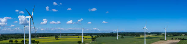 panoramablick auf die luft und nahaufnahme einer windkraftanlage in einem windpark mit rapsfeld - tim siegert stock-fotos und bilder