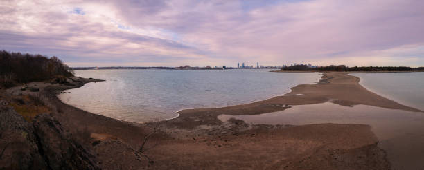 Panoramic Boston Harbor skyline and seascape. Nickerson Park beach and Sandbar to Thompson Island in Quincy Bay at low tide. stock photo