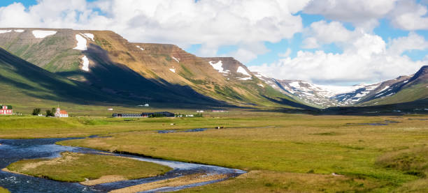 Panoramic of a valley with river and small buildings in Skagafjörður, in northern Iceland on a sunny day stock photo