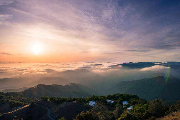 Photo of Panoramic view of a sunset over a sea of clouds covering south San Francisco bay area; beautiful rolling hills in the foreground; view from Mt Hamilton, San Jose