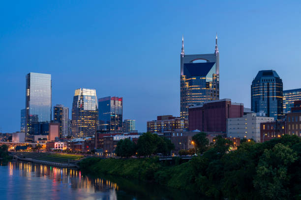 Panoramic view of Broadway district of Nashville over Cumberland River at illuminated night skyline, Tennessee, USA. This city is known as a center for the music industry, especially country music Panoramic view of Broadway district of Nashville over Cumberland River at illuminated night skyline, Tennessee, USA. This city is known as a center for the music industry, especially country music broadway nashville stock pictures, royalty-free photos & images
