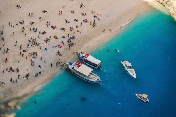 Panoramic view of moored leisure boats and bathers on famous Ionian Island beach, once voted as best in the world. stock photo